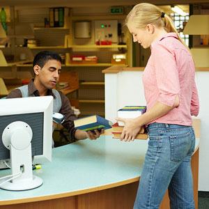 library assistant scanning books for check out